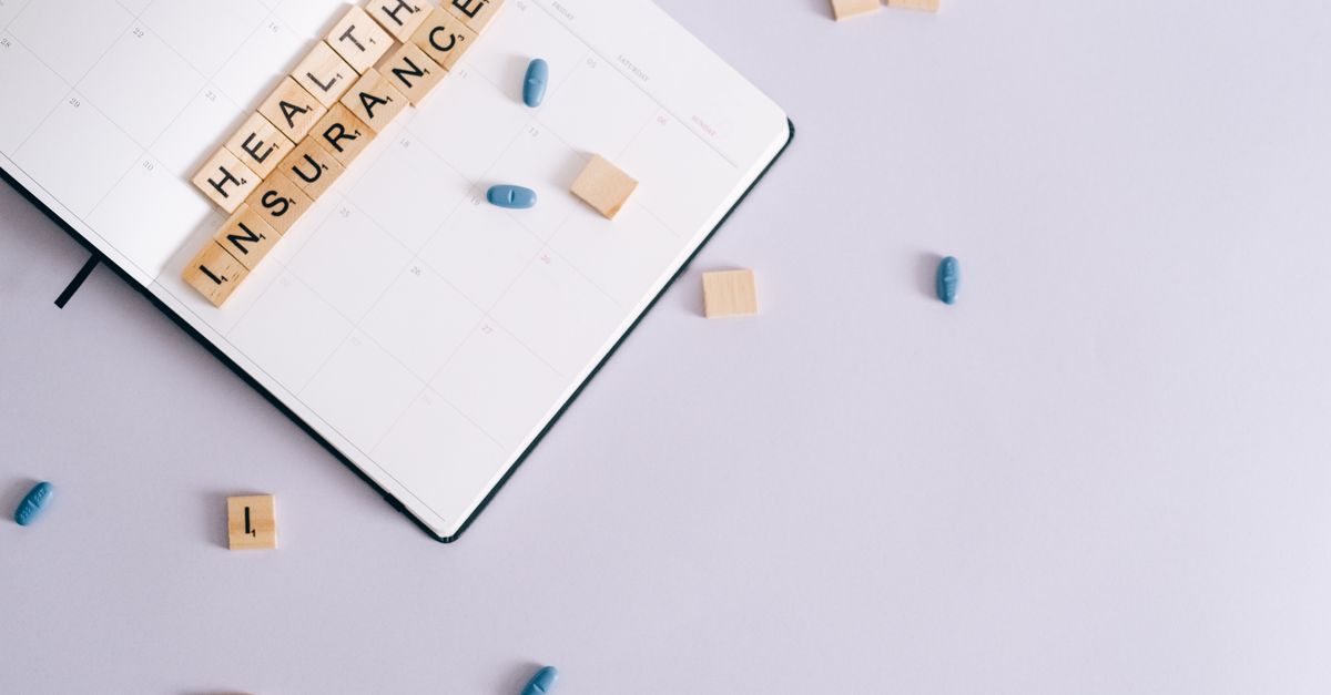 Flat lay of health insurance concept with planner and pills.